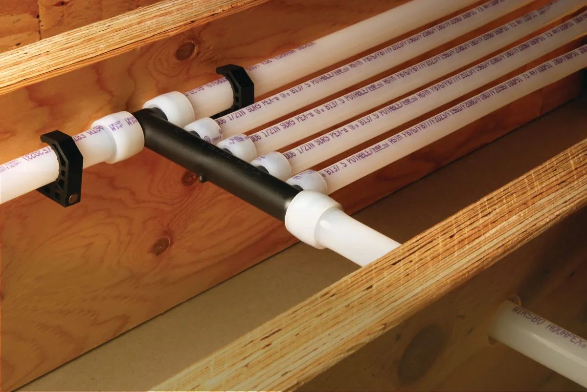 PEX-A multiport tee distributing water lines along joists, from our Coto de Caza guide: Rheem Tankless Water Heater Installation